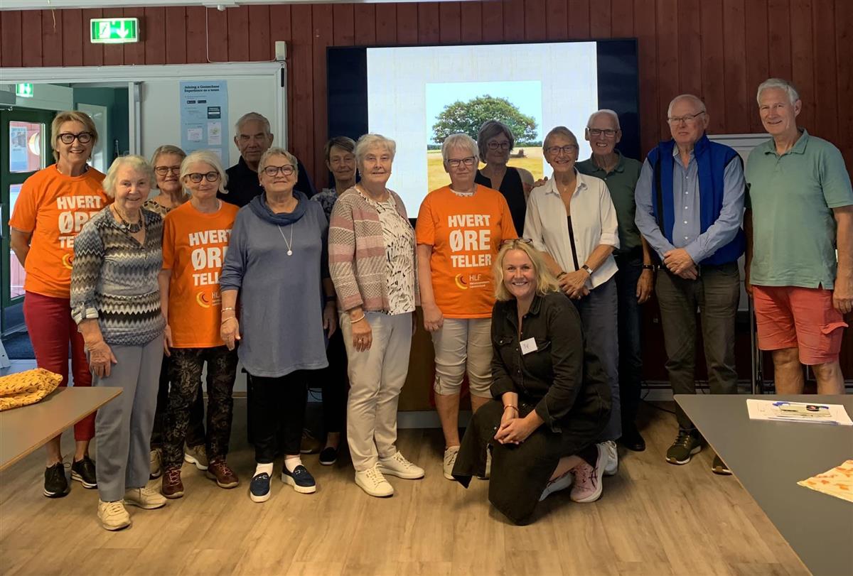 Flere seniorer samlet som ser på kameraet. Noen har teskjorte med teksten Hvert øre teller - Klikk for stort bilde