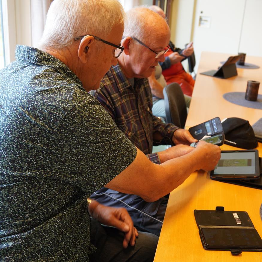 To menn kikker på en mobiltelefon sammen - Klikk for stort bilde